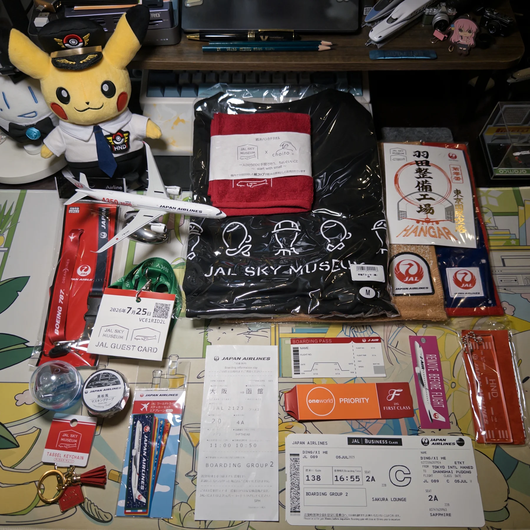 Japan Airlines collectibles including boarding passes, Sky Museum objects, cabin keepsakes, and an aircraft model