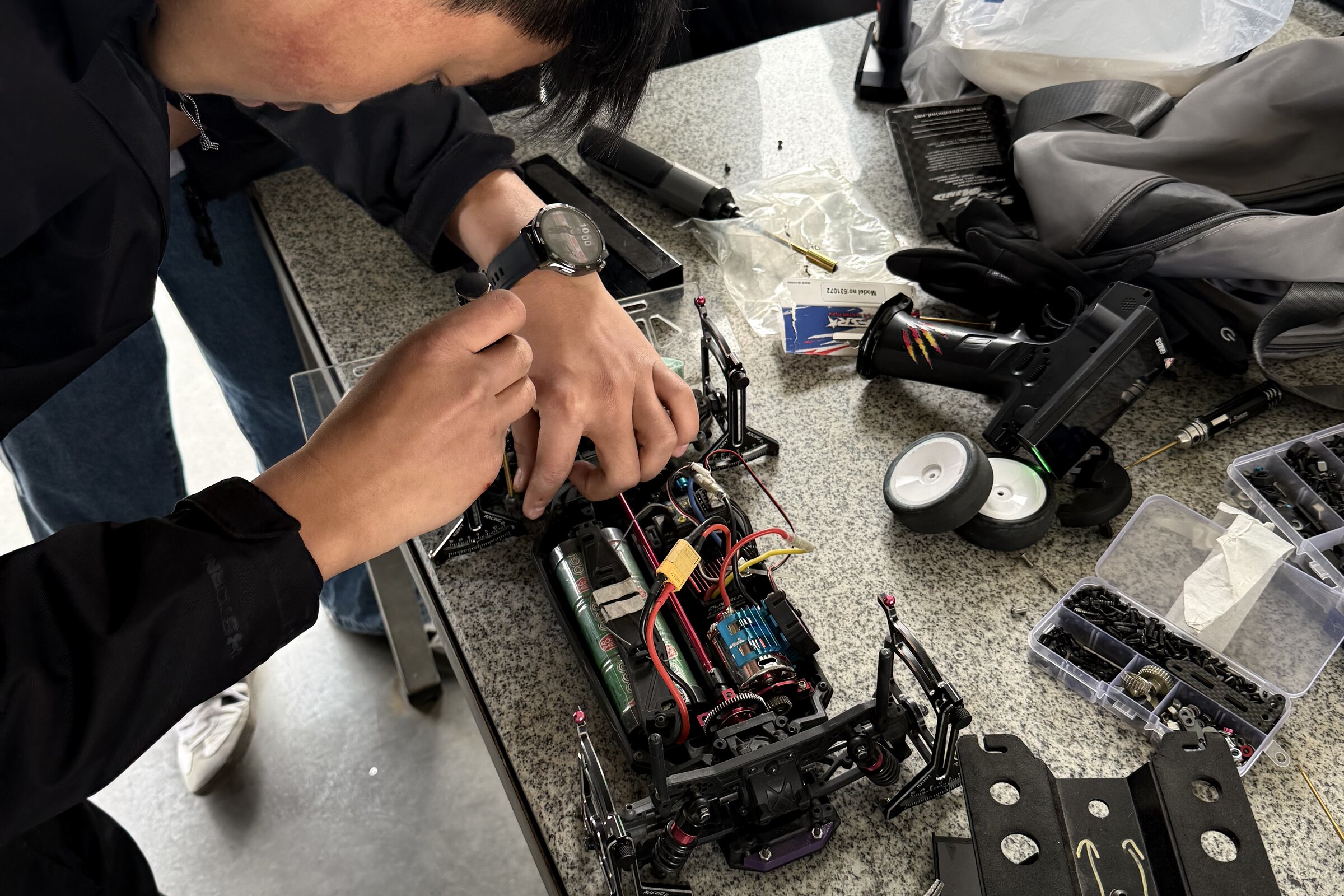A GT Racing member diagnosing a race chassis at a workbench in February 2026
