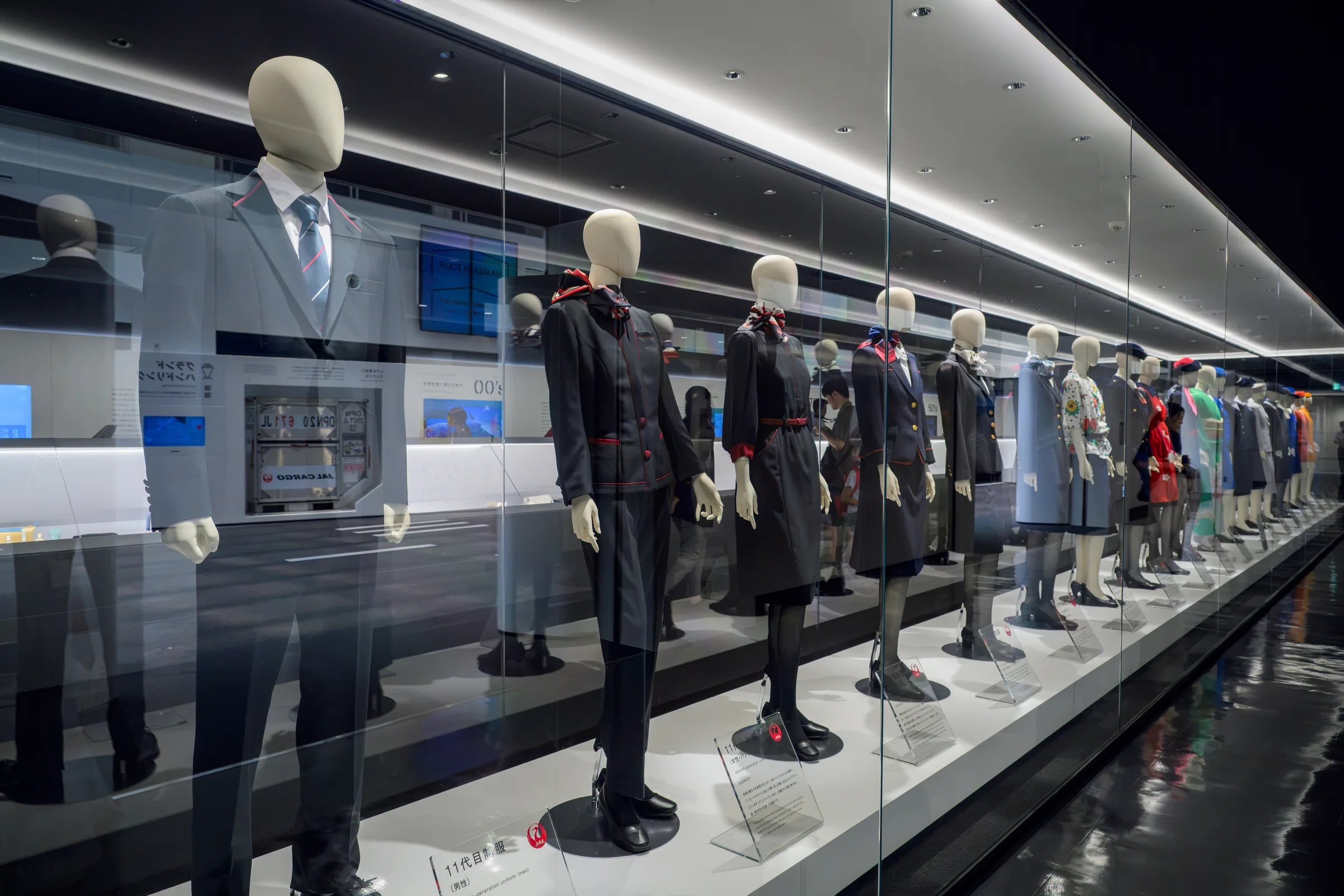 A row of historic airline uniforms displayed at the JAL Sky Museum