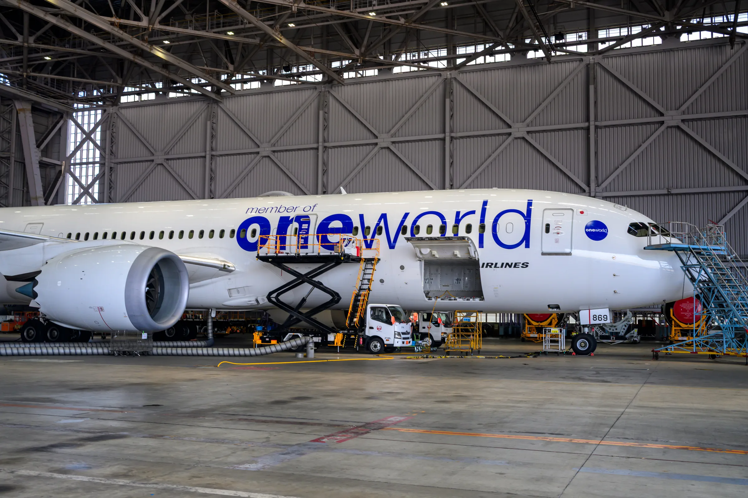 A Japan Airlines oneworld aircraft standing inside the maintenance hangar
