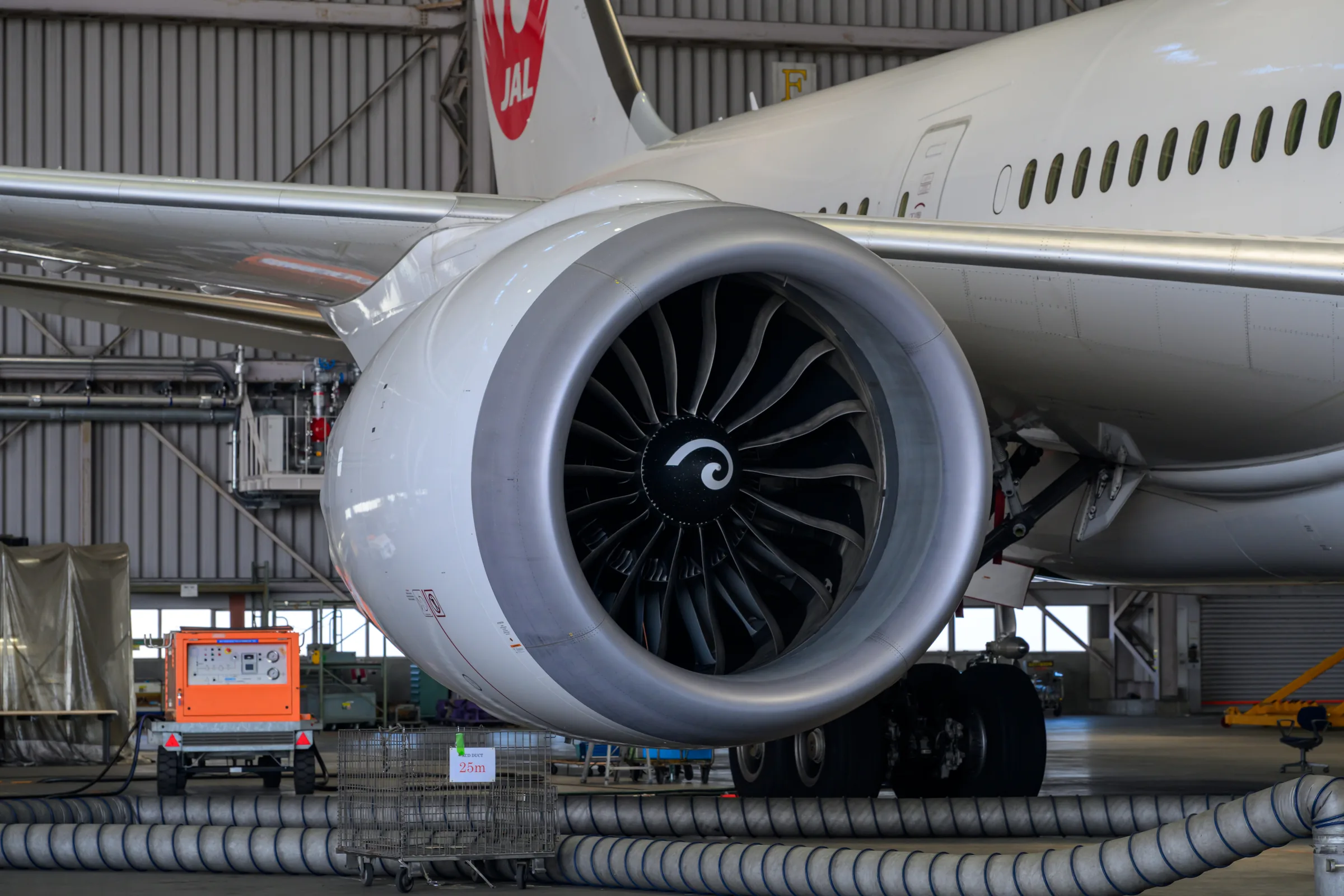 A close frontal view of a turbofan engine and maintenance equipment