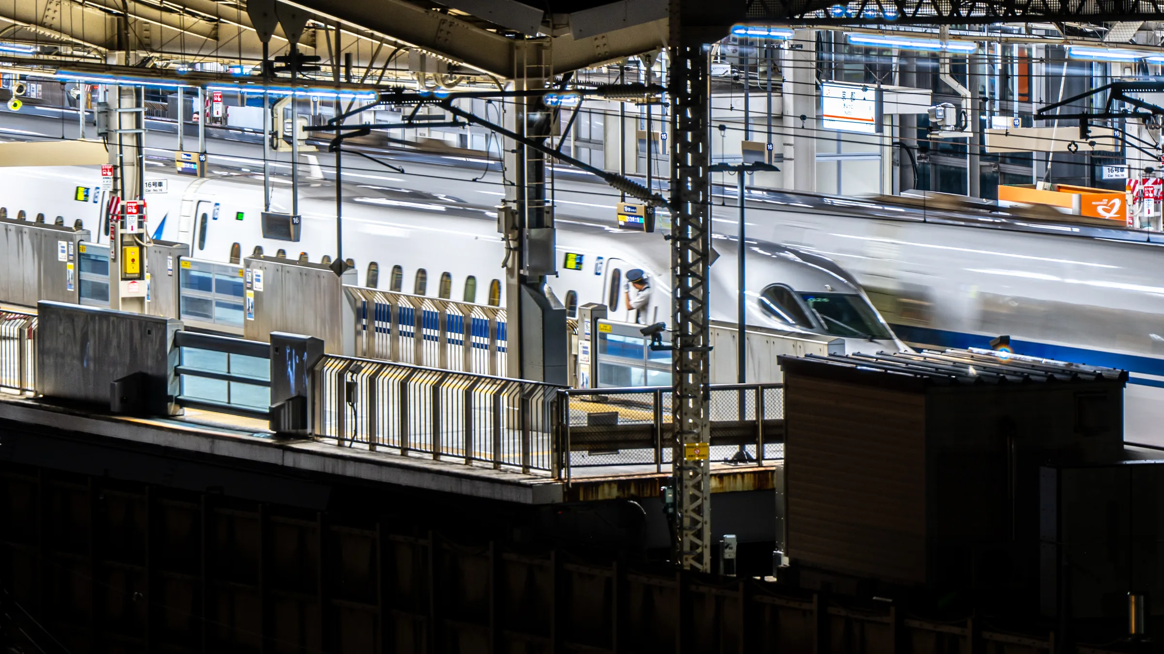 Two Shinkansen trains crossing through the layered lights of Kyoto Station