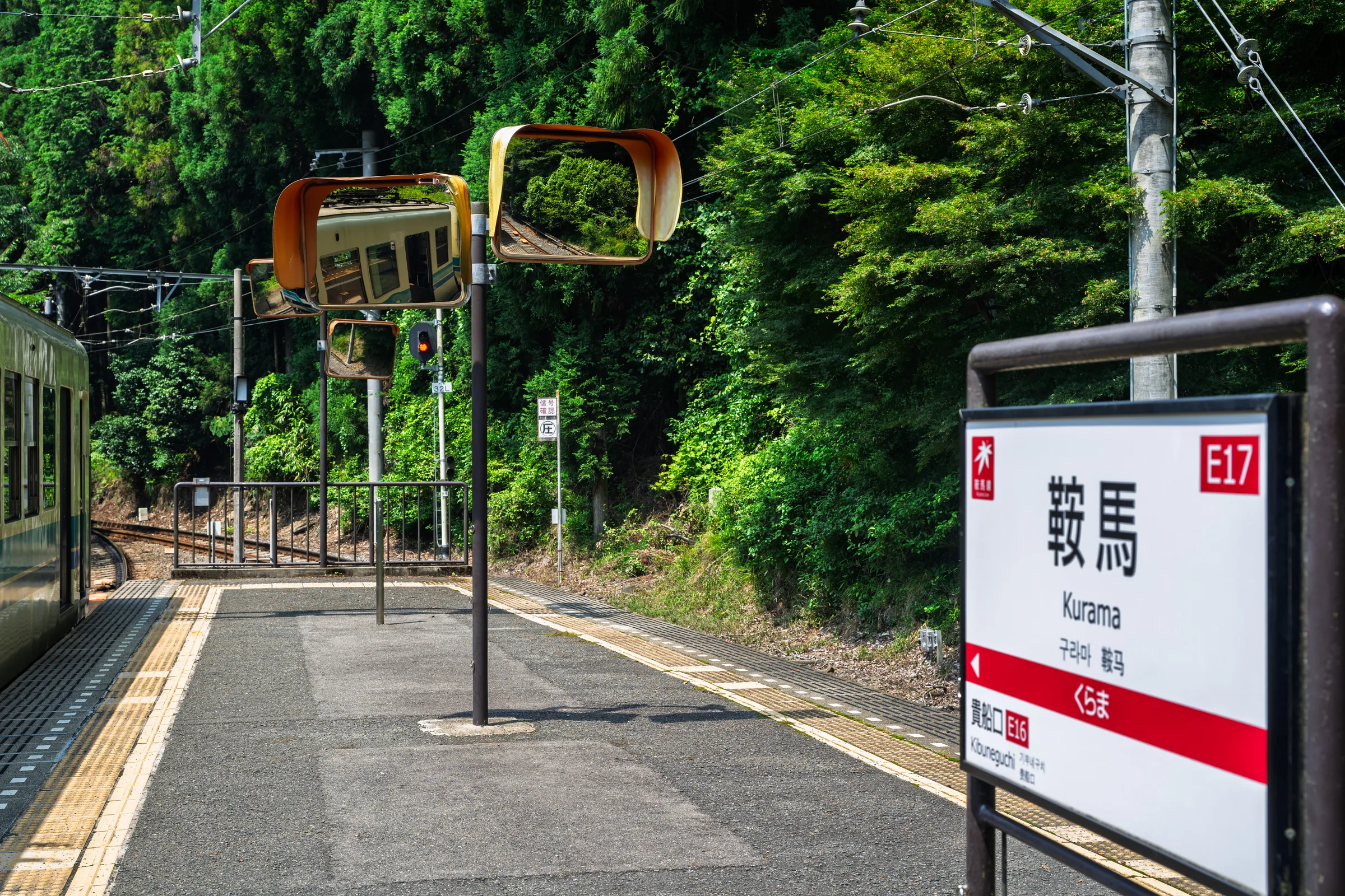 The Kurama Station sign beside platform mirrors and an Eizan train