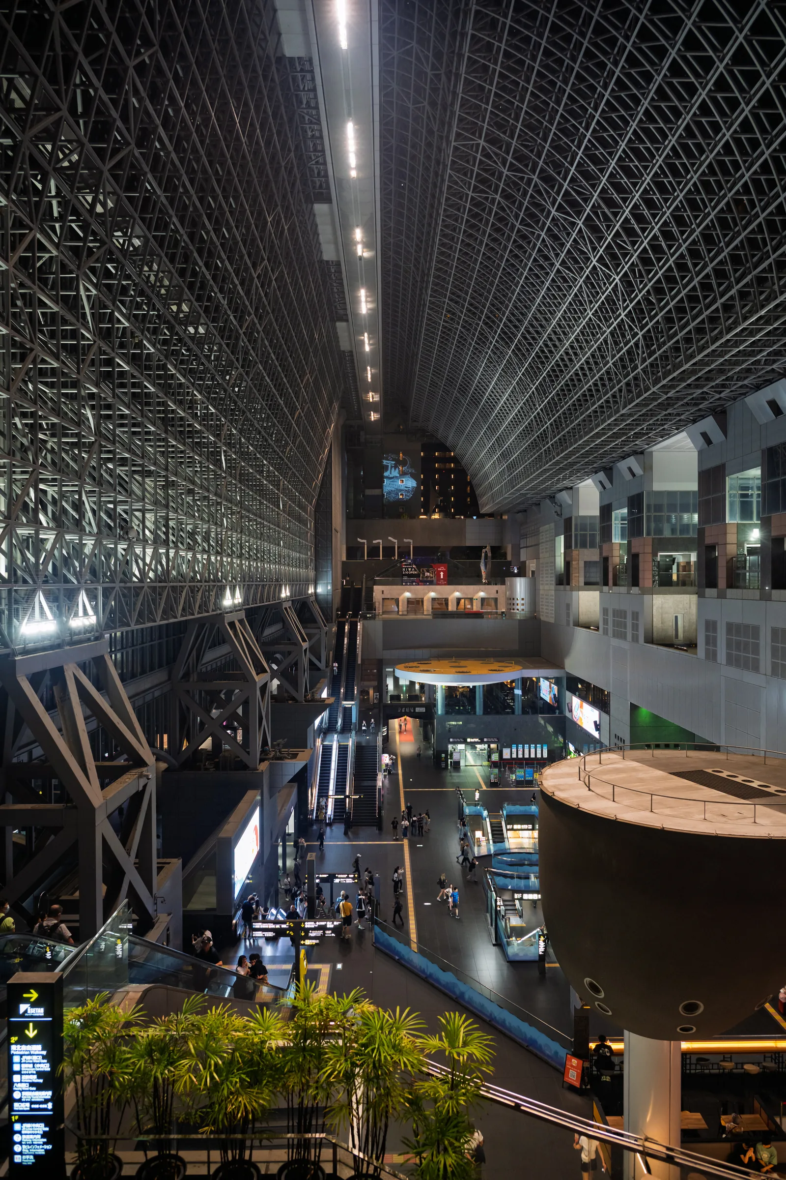 The immense steel-and-glass atrium of Kyoto Station seen from an upper level