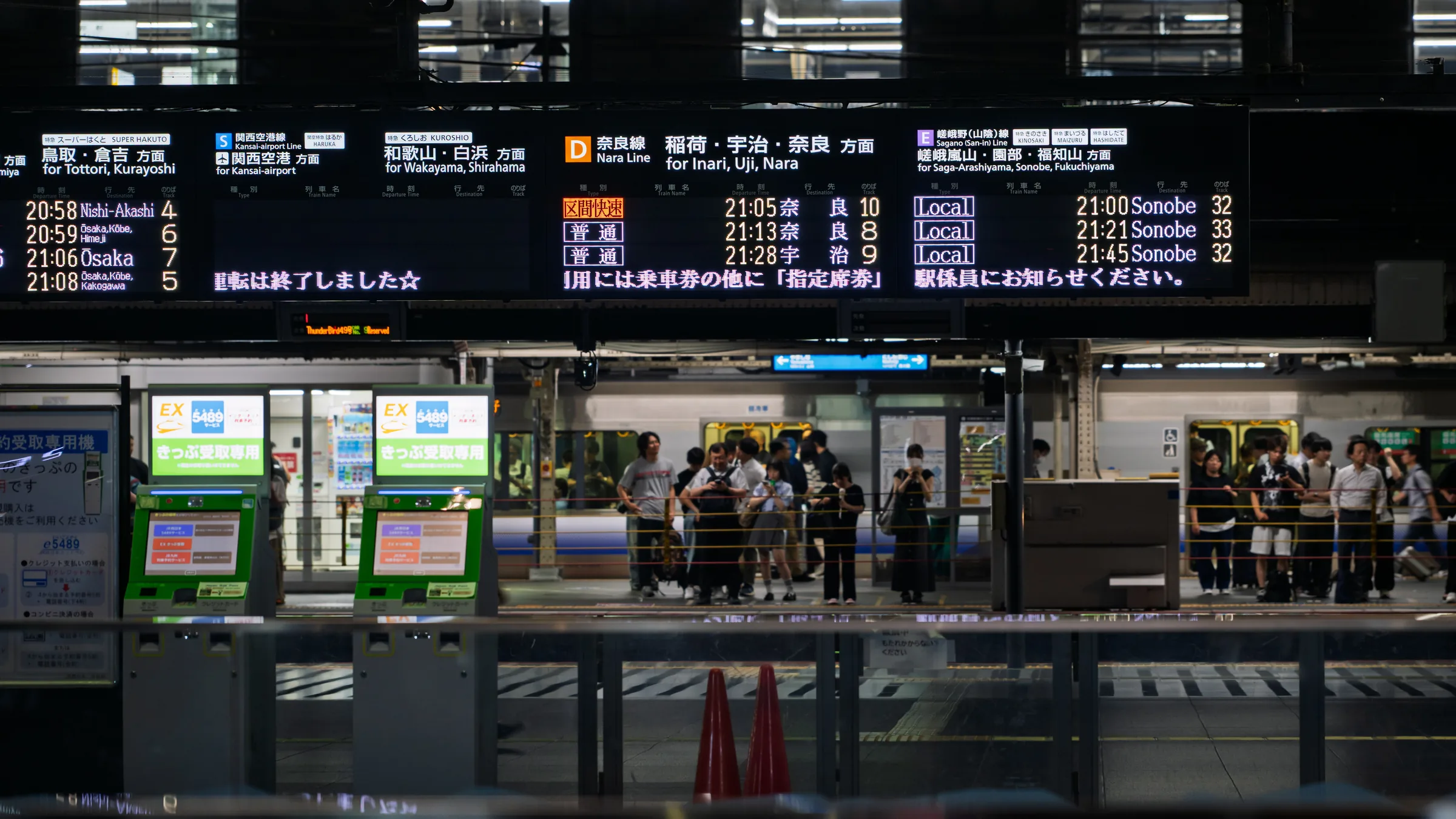 Passengers gathered beneath dense departure boards and ticket information screens
